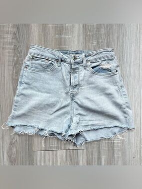 Light blue high rise denim shorts with frayed bottoms and button closure